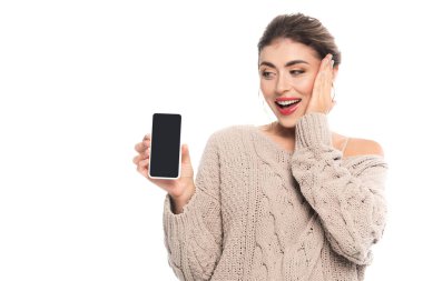 Beyazlar üzerinde izole edilmiş yüzlere dokunurken elinde boş ekranla akıllı telefonu tutan hayrete düşmüş kadın.