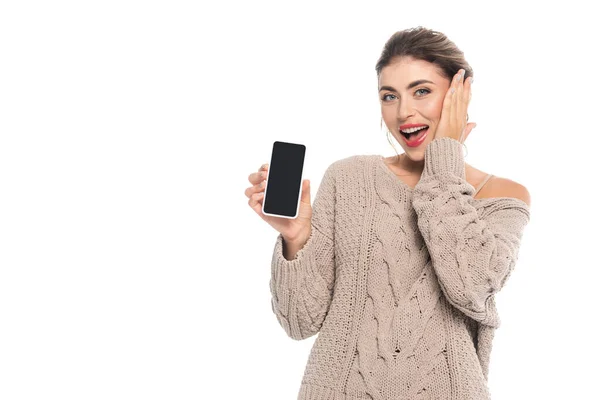 兴奋的女人 一边用空白屏幕展示智能手机 一边摸着被白色隔离的脸 — 图库照片