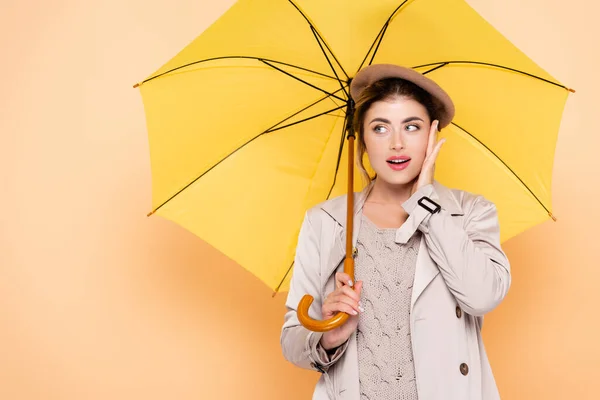 Módní Žena Podzimním Oblečení Dotýkající Obličeje Odvracející Pod Žlutým Deštníkem — Stock fotografie