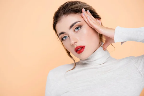 Woman Turtleneck Looking Camera While Touching Face Isolated Peach — Stock Photo, Image