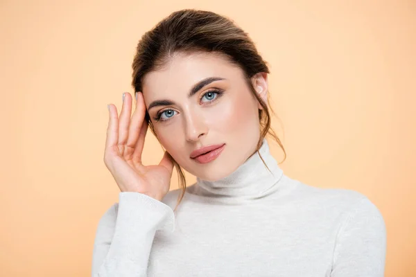 Sensual Woman Turtleneck Touching Face While Looking Camera Isolated Peach — Stock Photo, Image