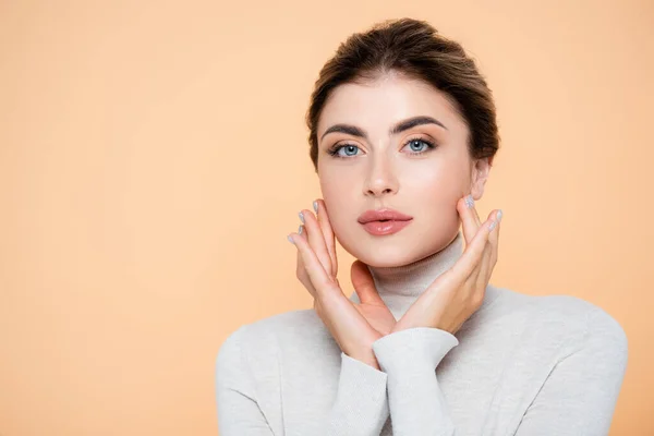 Sensual Woman Turtleneck Touching Face While Looking Camera Isolated Peach — Stock Photo, Image