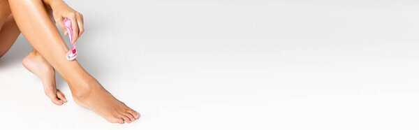 Woman shaving smooth leg with safety razor on white, banner