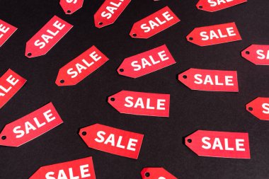 red labels with sale lettering on black background  clipart