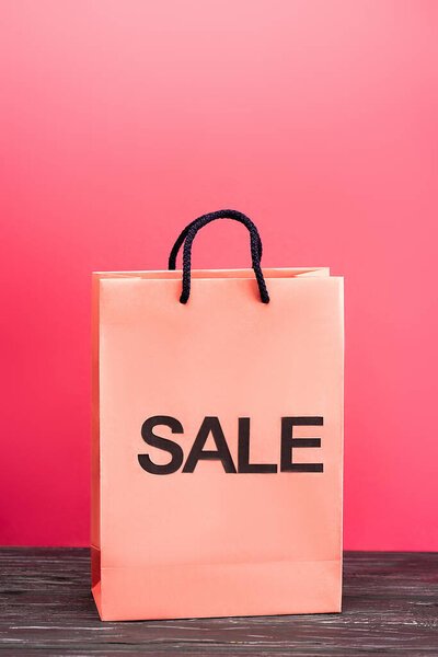 shopping bag with sale lettering on pink, black friday concept 