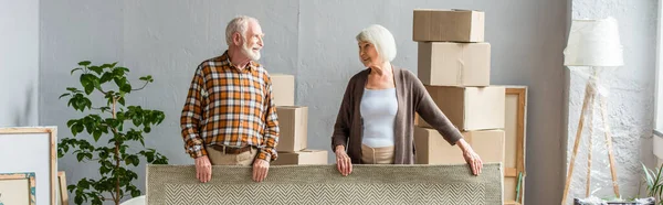 Panoramic Shot Senior Couple Rolling Carpet Boxes Frames Plant Background — Stock Photo, Image