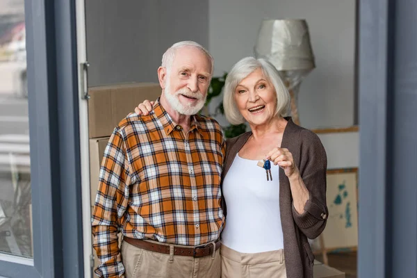 Lachen Senior Vrouw Met Sleutels Omarmen Echtgenoot Nieuw Huis — Stockfoto