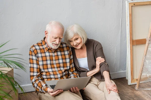 Glückliches Seniorenpaar Mit Laptop Auf Dem Boden Sitzend Bewegtes Konzept — Stockfoto
