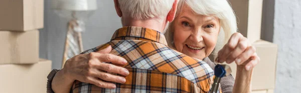 Panoramic Shot Smiling Senior Woman Holding Keys Hugging Husband Moving — Stock Photo, Image