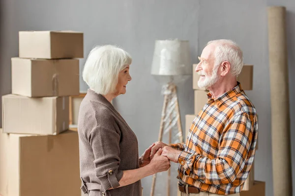 Pareja Ancianos Tomados Mano Mirándose Uno Otro Una Casa Nueva — Foto de Stock