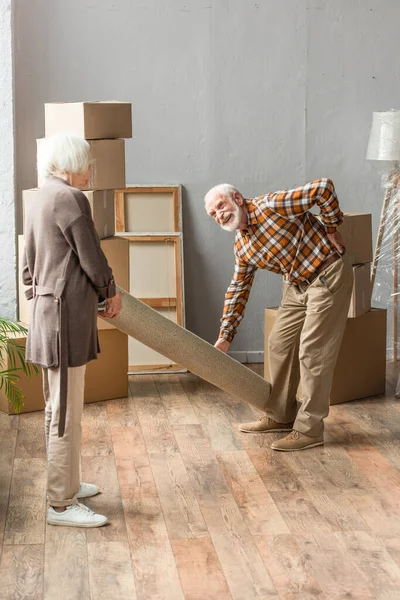 Full Length Senior Man Suffering Backache While Rolling Carpet Wife — Stock Photo, Image