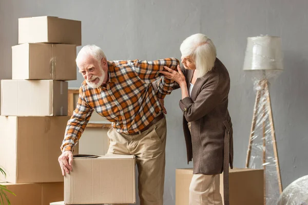 Senior Man Suffering Backache Holding Box While Wife Trying Help — Stock Photo, Image
