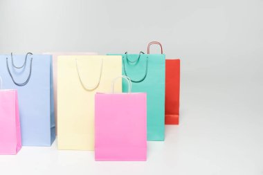 Gri arka planda renkli alışveriş çantaları, Kara Cuma konsepti 