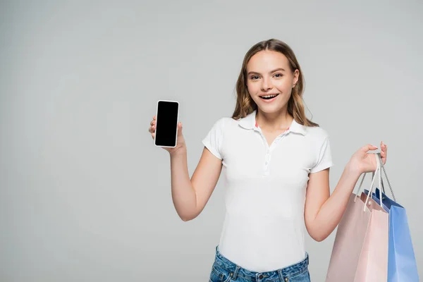 Mulher Alegre Segurando Smartphone Com Tela Branco Sacos Compras Isolados — Fotografia de Stock