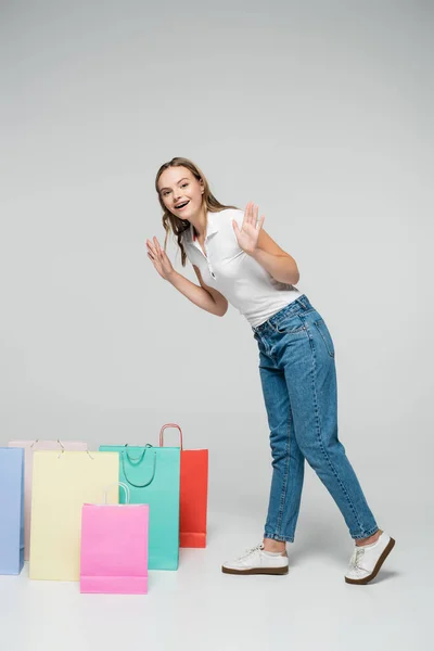 Mulher Animado Gesticular Enquanto Está Perto Sacos Compras Conceito Cinza — Fotografia de Stock