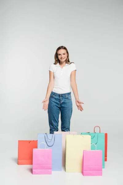 Jovem Mulher Alegre Apontando Com Mãos Para Sacos Compras Conceito — Fotografia de Stock