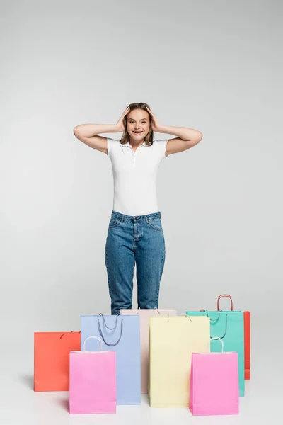 Joven Emocionada Mujer Pie Tocando Pelo Cerca Bolsas Compras Gris — Foto de Stock