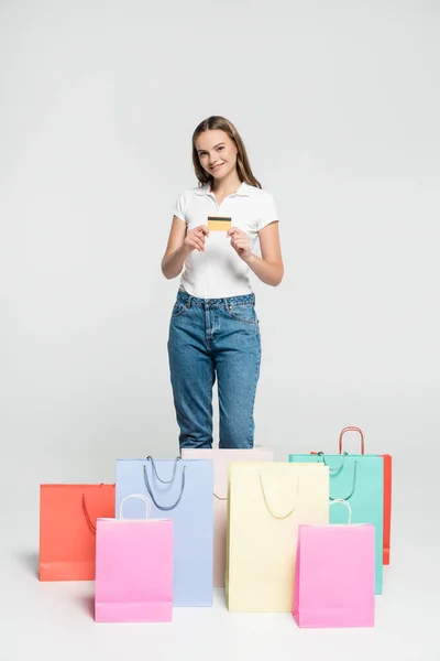 Complacida Joven Sosteniendo Tarjeta Crédito Cerca Bolsas Compras Gris Concepto — Foto de Stock