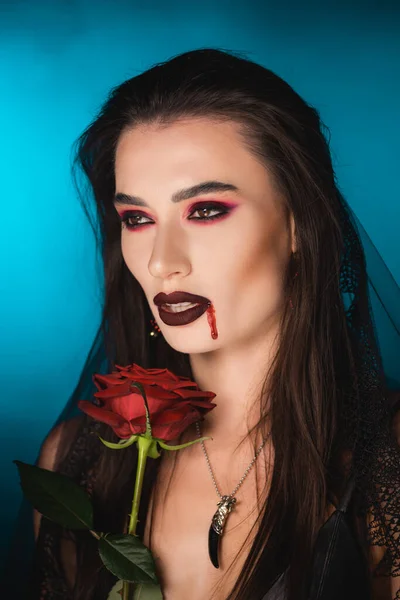 Przerażająca Kobieta Krwią Twarzy Pobliżu Czerwonej Róży Niebiesko — Zdjęcie stockowe