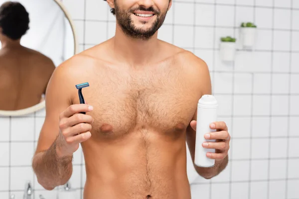 トイレでカミソリとシェービング泡を保持している愚かな男の笑顔の作物ビュー — ストック写真