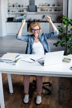 young blonde woman in eyeglasses happy with raised hands clipart