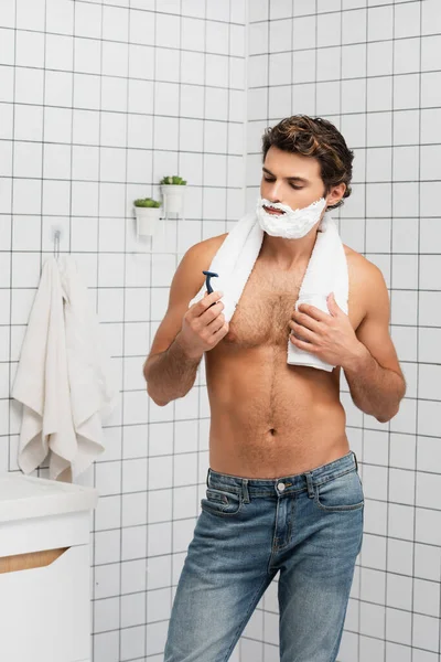 Shirtless Man Jeans Shaving Foam Face Holding Towel Razor Bathroom — Stock Photo, Image