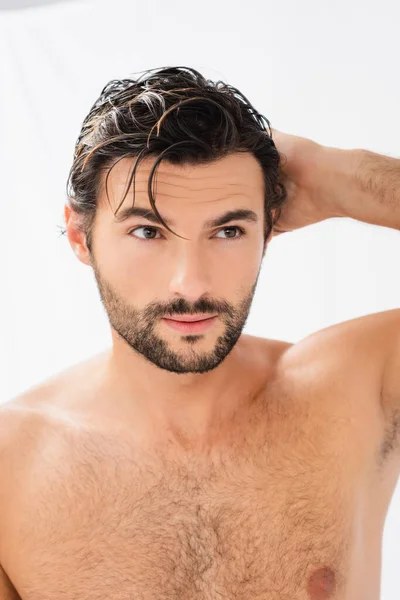 Shirtless man with wet hair looking away on grey background