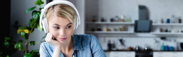 young blonde woman in headphones leaning on hand and looking down, banner