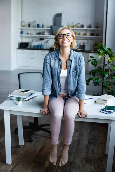 Mujer Rubia Sonriente Gafas Vista Sentada Mesa Casa —  Fotos de Stock