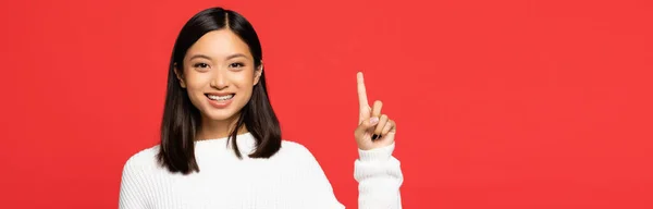 Happy Asian Woman Sweater Pointing Finger Isolated Red Banner — Stock Photo, Image