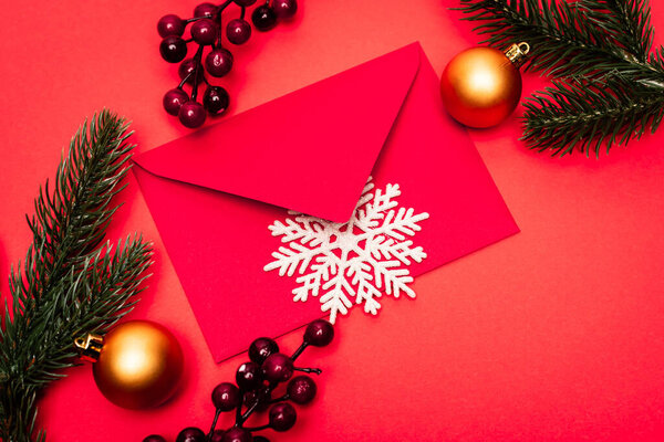 top view of Christmas decoration and envelope on red background