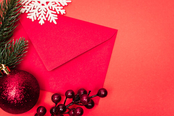 top view of Christmas decoration and envelope on red background