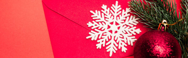 top view of Christmas decoration and envelope on red background, banner