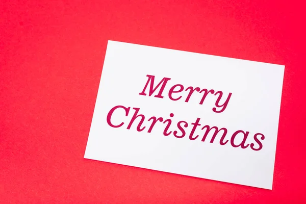 赤い背景に白いメリー クリスマスカードの上からの眺め — ストック写真