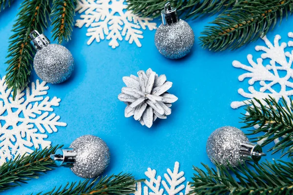 Top view of snowflakes, silver baubles and spruce with cone on blue background — Stock Image Top View Snowflakes Silver Baubles Spruce Cone Blue Background Stock Picture
