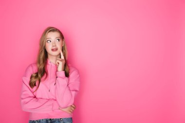 Pembe arka planda düşünceli güzel kadın