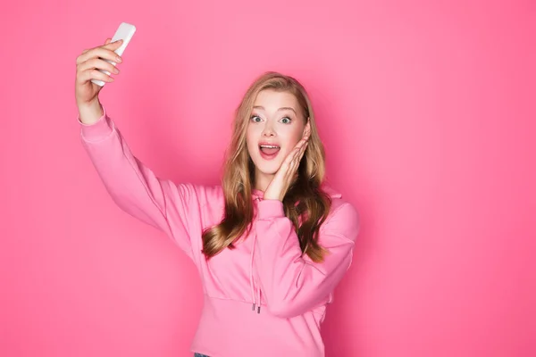 Geschokt Mooie Vrouw Het Nemen Van Selfie Smartphone Roze Achtergrond — Stockfoto