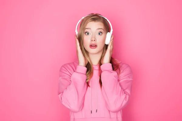 Шокована Красива Жінка Слухає Музику Навушниках Рожевому Фоні — стокове фото