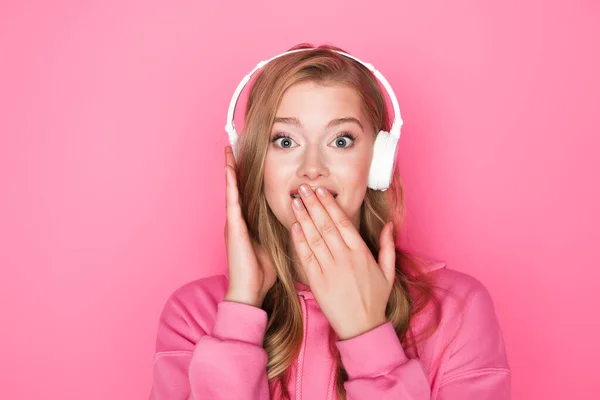 Shocked Beautiful Woman Listening Music Headphones Covering Mouth Pink Background — Stock Photo, Image