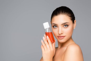beautiful woman with bottle of lotion isolated on grey clipart
