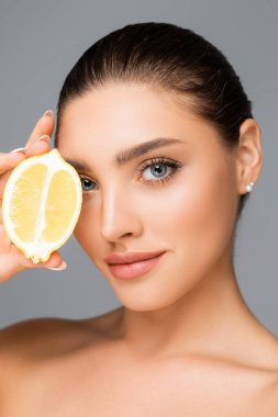 Çıplak omuzlu ve limonlu bir kadın.