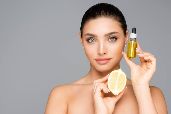 woman with serum and lemon half isolated on grey