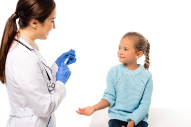 Gülen çocuk doktoru lateks eldivenli. Yanında beyaz bir çocuğun şırıngası var.