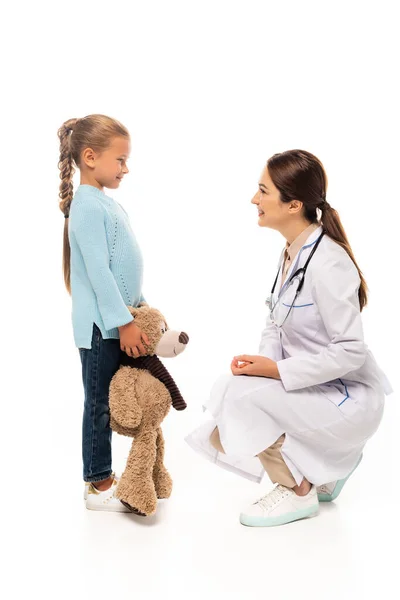 Arzt Lächelt Kind Mit Stofftier Auf Weißem Hintergrund — Stockfoto