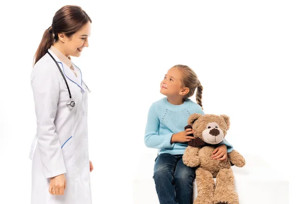 Arzt Lächelt Mädchen Mit Teddybär Auf Weißem Tisch — Stockfoto