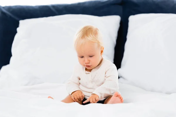 Menino Apontando Com Dedo Enquanto Sentado Cama Fundo Branco — Fotografia de Stock