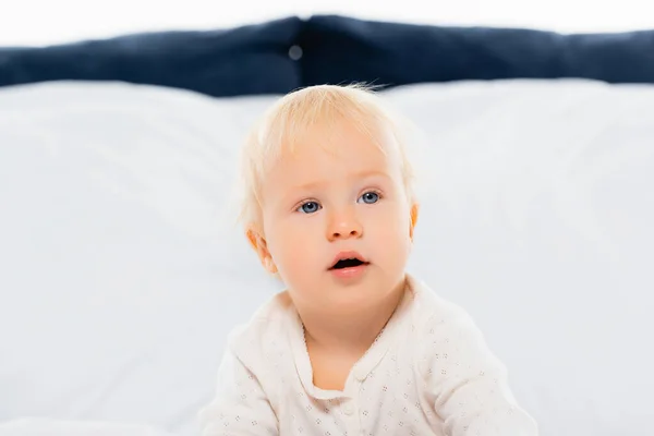 Blonde Kleinkind Junge Blick Weg Auf Bett Auf Weißem Hintergrund — Stockfoto