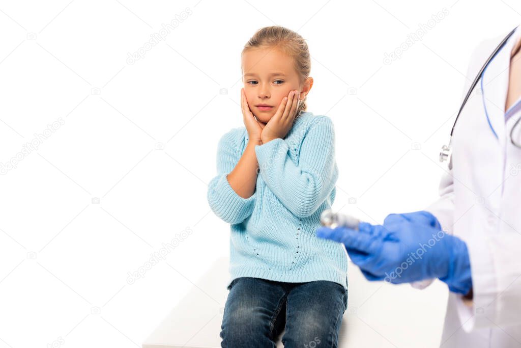 Selective focus of scared kid looking at doctor with vaccine isolated on white
