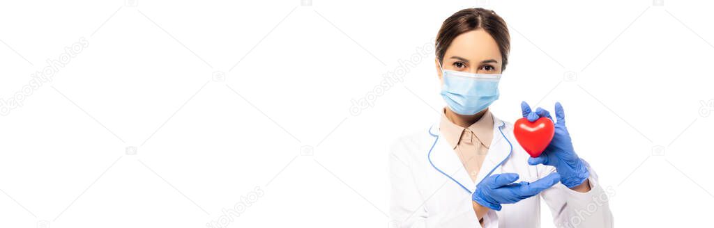 Horizontal crop of doctor in medical mask showing heart isolated on white