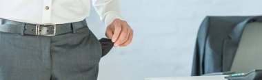 Cropped view of businessman showing empty pocket on blurred background, banner clipart
